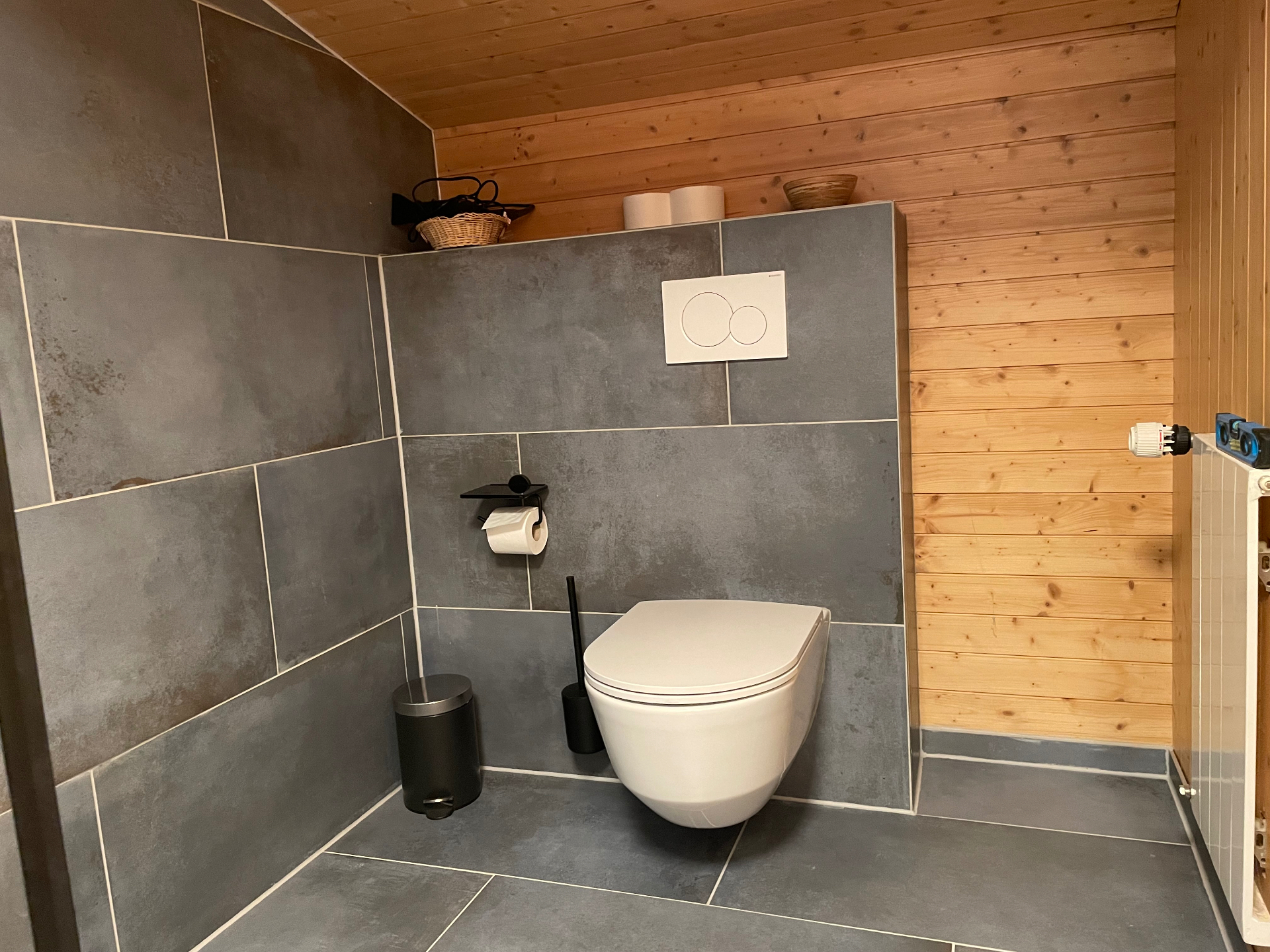 WC mit Schieferfliesen und warmer Holzvertäfelung